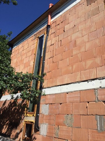 Solární potrubí na stěně domu před zateplením