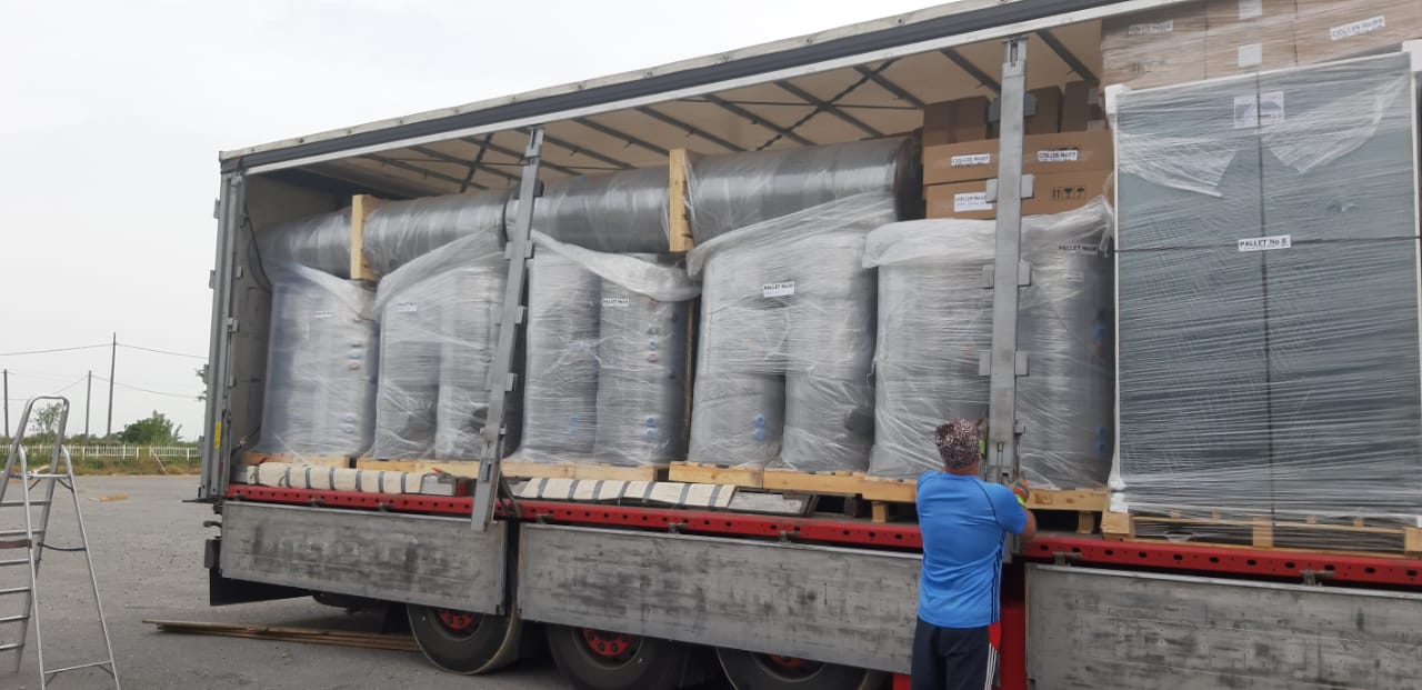 Nákladní auto plné solárních kolektorů a zásobníků vody