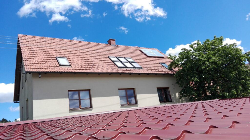 Dům s červenou střechou a okny.